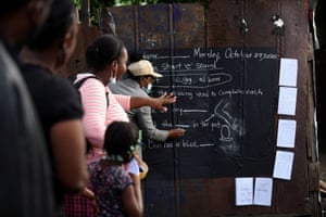  Педагог Танека Маккой Фиппс пишет урок на доске, нарисованной на цинковом заборе, в малообеспеченном районе Кингстона. 